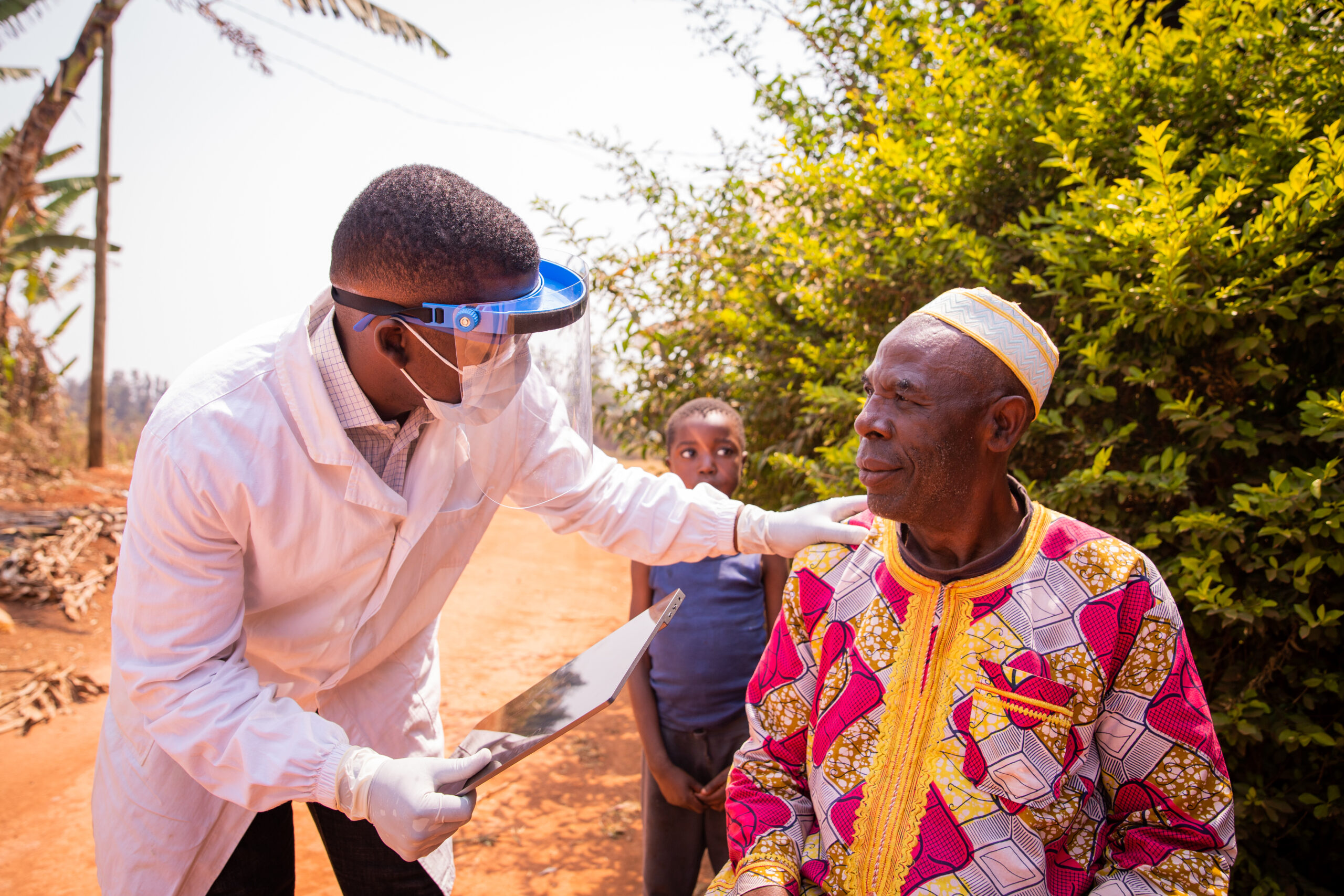 African doctor visits an elderly patient and they converse during the medical examination.